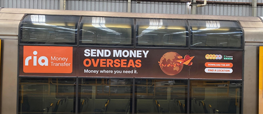 RIA Money Transfer ad on a train exterior panel